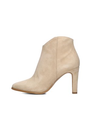 Bottine en daim beige avec un bout pointu et un talon aiguille de 7,5 cm. Présente une texture lisse et peu de détails de couture.