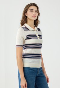 Kurzarm-Polohemd in Creme mit Marineblau und Burgunderstreifen, mit einem Kragen und einer Knopfleiste mit drei Knöpfen, strukturierter Strickdesign.