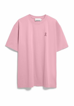 T-shirt à manches courtes rose clair avec col rond, petit logo rose foncé sur le côté gauche de la poitrine et étiquette de la marque au niveau du col.