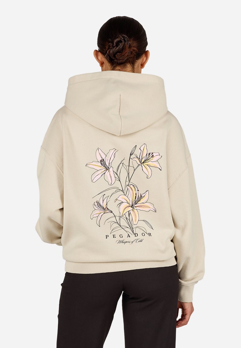 Felpa beige con cappuccio caratterizzata da un design floreale con gigli rosa sulla schiena, scritte nere e polsini e orlo a coste.
