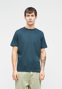 Ναυτικό μπλε κοντομάνικο μπλουζάκι με στρογγυλή λαιμόκοψη, φτιαγμένο από βαμβάκι. Εχει χαλαρή εφαρμογή και μαλακή υφή. Χωρίς ορατά σχέδια ή λογότυπα.