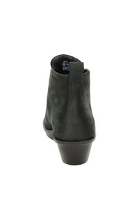 Botines de ante negro con un tacón bajo, textura suave y un tirador en la parte trasera. Presentan detalles de costura y un diseño de puntera redondeada.