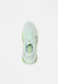 Tenis verde deschis cu un material mesh, talpă texturată, accente neon contrastante și șireți plata. Proiectat pentru confort și performanță.