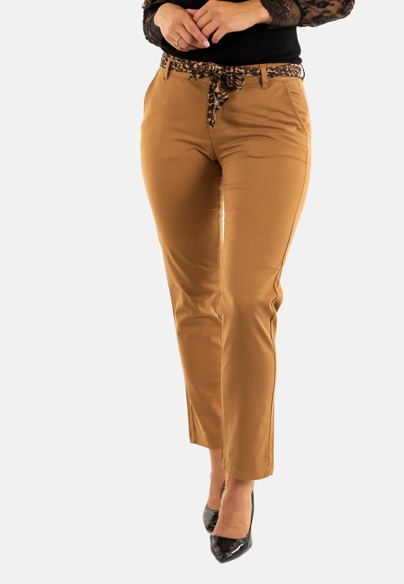 Bruine broek met een aansluitend ontwerp, voorzien van een leoprint riem en een gladde textuur, gecombineerd met zwarte hoge hakken.