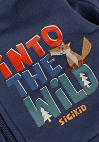 Dunkelblauses Hemd mit dem Text "INTO THE WILD" in fetten, mehrfarbigen Buchstaben und einem gestickten Fuchs-Detail. Markenname "Sigikid" enthalten.