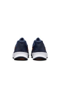 Chaussures de sport bleues avec une tige synthétique lisse, un col rembourré, une semelle en caoutchouc et des accents de logo orange. Design simple avec une forme arrondie à l'arrière.