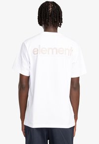 Camiseta de algodón blanca con un gran logo beige de "element" en la parte posterior. Manga corta y corte relajado.