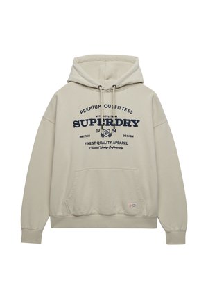 Sudadera con capucha beige con bolsillo delantero y texto "Superdry" en azul marino junto con un logo de estilo vintage impreso en el pecho.