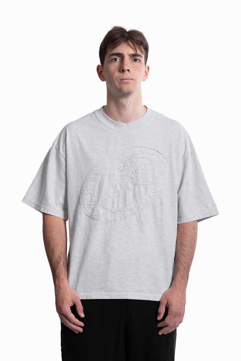 Grijze oversized T-shirt van katoen, met een gestructureerd rond ontwerp op de voorkant. Korte mouwen en een ronde hals.