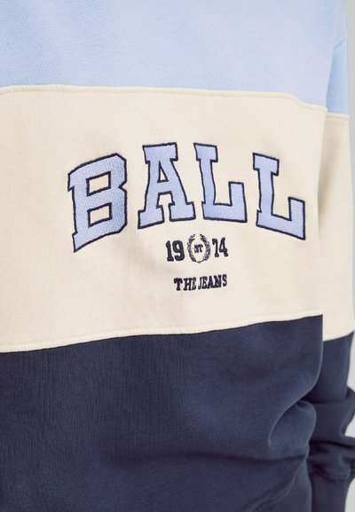Kuppet genser i bomull med horisontalt fargeblokkdesign i lys blå, krem og marineblå. Brodert "BALL"-logo med år og tekstaksent.