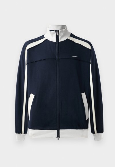 Jachetă sport de culoare bleumarin cu fermoar, cu accente albe, guler și manșete ribbed, două buzunare laterale și un mic logo pe piept. Textură a țesăturii netedă.