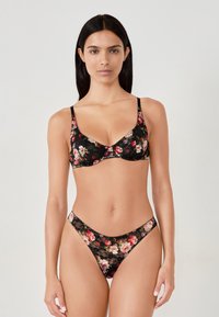 Schwarzes Blumen-Spitzenbikini-Set mit einem BH mit feinen Trägern und einem passenden hochgeschnittenen Tanga. Blumenmuster in Pink- und Rottönen.