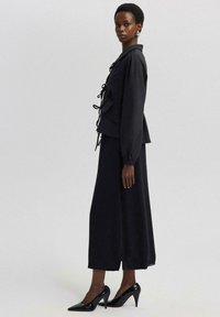 Touché Privé RUFFLE DETAILED CREPE CROP - Kerge jope - black