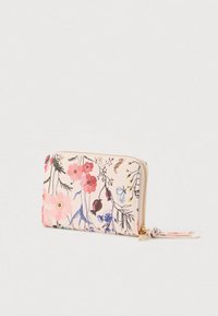 Portefeuille zippé floral en tissu rose pâle, ornée de fleurs multicolores et de branches, avec une quincaillerie dorée et une tirette de zip assortie.