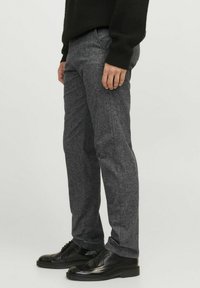 Grijze textuurbroek met een slim fit, voorzien van een gladde stof, zijzakken en een subtiel patroon; gecombineerd met zwarte leren schoenen.