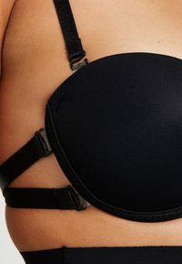 Sutiã preto com copas moldadas, alças ajustáveis e fecho com colchete. Tecido texturizado com acabamento suave e detalhes de hardware em contraste.