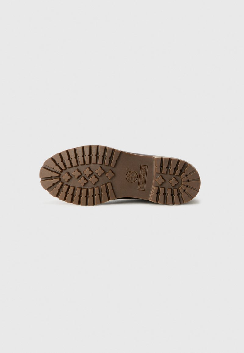 Brown rubber boot sole with deep treads and Timberland logo imprinted in the center, isolated on a gray background.