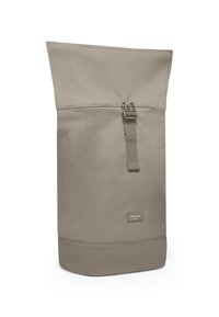 Korkea beige rullatop-reppu, jossa on etukulmasolki ja "Larkson Hamburg" -etiketti lähellä pohjaa.