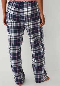 Donkerblauwe en witte geruite pyjamabroek met roze accenten, gemaakt van zachte stof, met een elastische tailleband en losse rechte pijpen.