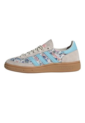 Hellbeige Wildleder-Sneaker mit blauen Blumenstoff-Paneelen, drei blauen Streifen, Gummisohle und dem Schriftzug „SPEZIAL“ an der Seite.