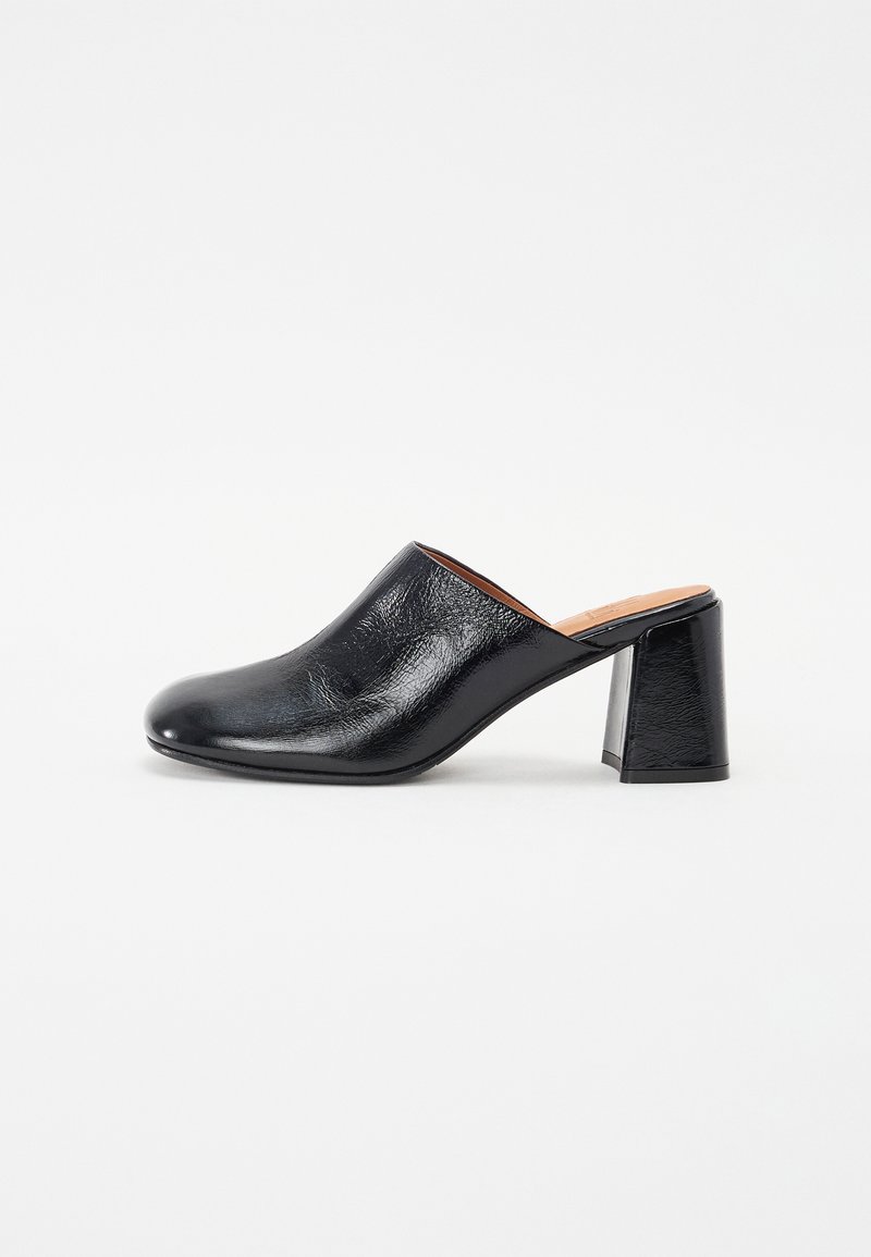 Mules en cuir noir avec une texture lisse, bout rond et un talon carré de hauteur intermédiaire affichant un éclat subtil.