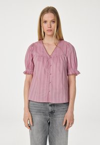Roze blouse met korte mouwen, een v-hals, textuurstreepjes en een knoopsluiting. Beschikt over pofmouwen met kantafwerking en een ruime pasvorm.