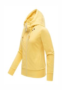 Sweat à capuche zippé jaune avec cordon de serrage à la capuche, manches longues et poches latérales, présenté sur un mannequin partiel sur fond blanc.