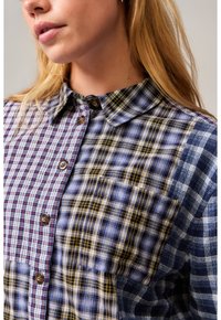 Bunt kariertes Hemd mit einer Mischung aus blau-, rot- und gelbfarbenen Mustern. Mit Button-Down-Kragen, Brusttasche und strukturiertem Stoff.