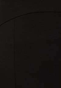 Tissu noir à texture lisse, avec des coutures courbées, créant une allure ajustée avec un léger éclat. Aucuns motifs ou accents visibles.