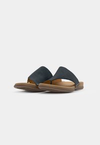 Svarta mocka slip-on sandaler med en bred rem, öppen tå och en brun vadderad sula. Har en texturerad gummisula för bra grepp.