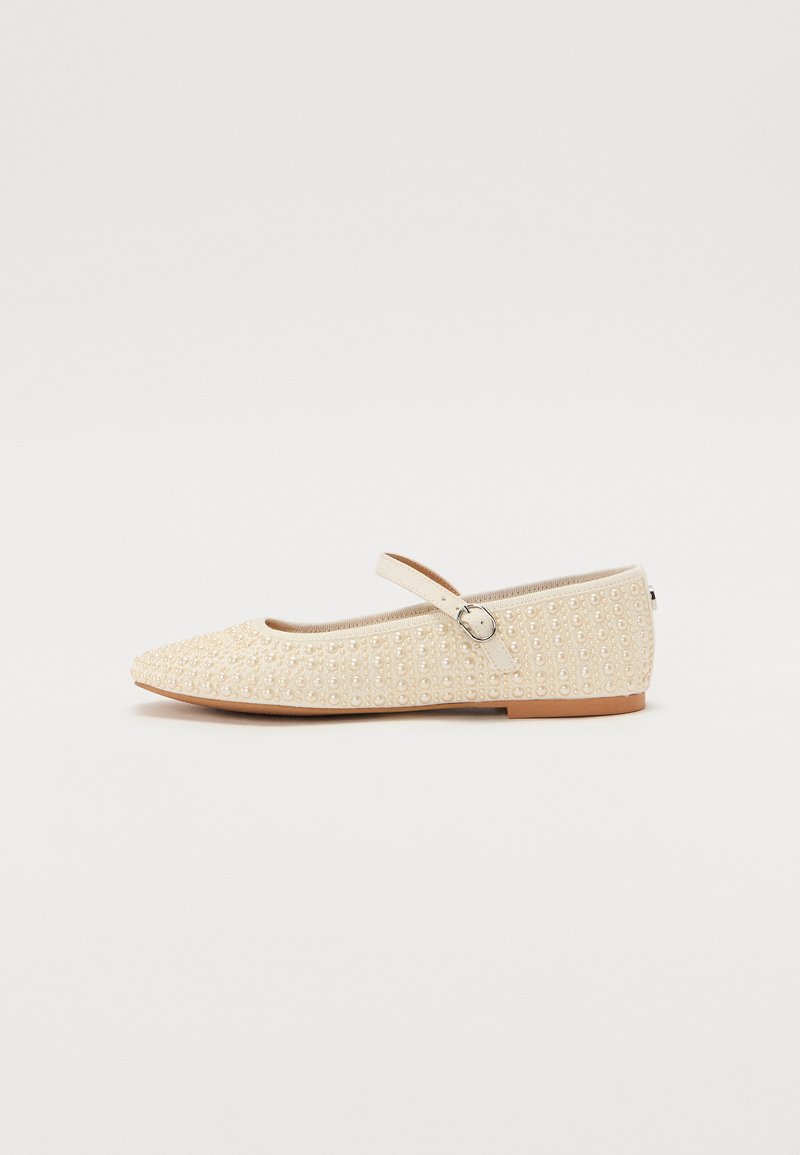 Scarpa Mary Jane piatta color crema con cinturino alla caviglia, decorata con perline di perla distribuite uniformemente, e un piccolo fibbia di lato.