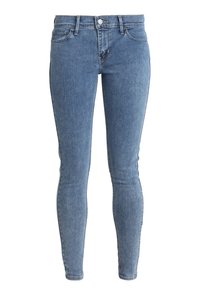 Jeans de mezclilla ligeros de corte slim en azul claro, con cierre de botón y cremallera en la parte delantera, diseño de cinco bolsillos y trabillas para cinturón.