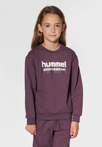 Lila Sweatshirt mit langen Ärmeln, versehen mit einem weißen „hummel SPORTSWEAR“-Logo auf der Brust sowie gerippten Bündchen und Saum. Aus Baumwollmischgewebe.
