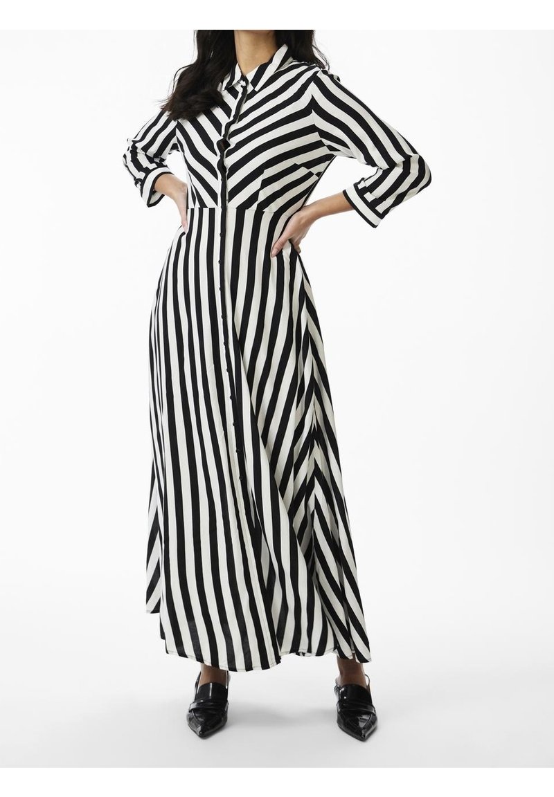 Musta-valkoiset raidalliset maksimekko pitkillä hihoilla, nappisulku, kauluspaita ja kaksi rintataskua. Sujuva kangas, jossa on virtaava muotoilu.