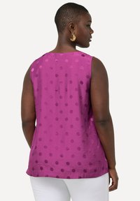 Mouwloze paarse blouse met een textuur van stippenpatroon, voorzien van een ronde halslijn en een rechte zoom, gemaakt van lichte stof.