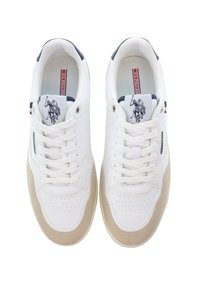 Valkoiset nahkakengät, joissa on beige mokkanahka yksityiskohtia, reikäkuvioitu varvasosa ja litteät nauhat. Sisältää tummansinisen kantapään ja brodeeratun logon.