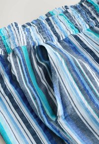 Tissu rayé bleu et blanc avec une taille élastiquée à texture froncée. Rayures dans diverses nuances de bleu et de turquoise.