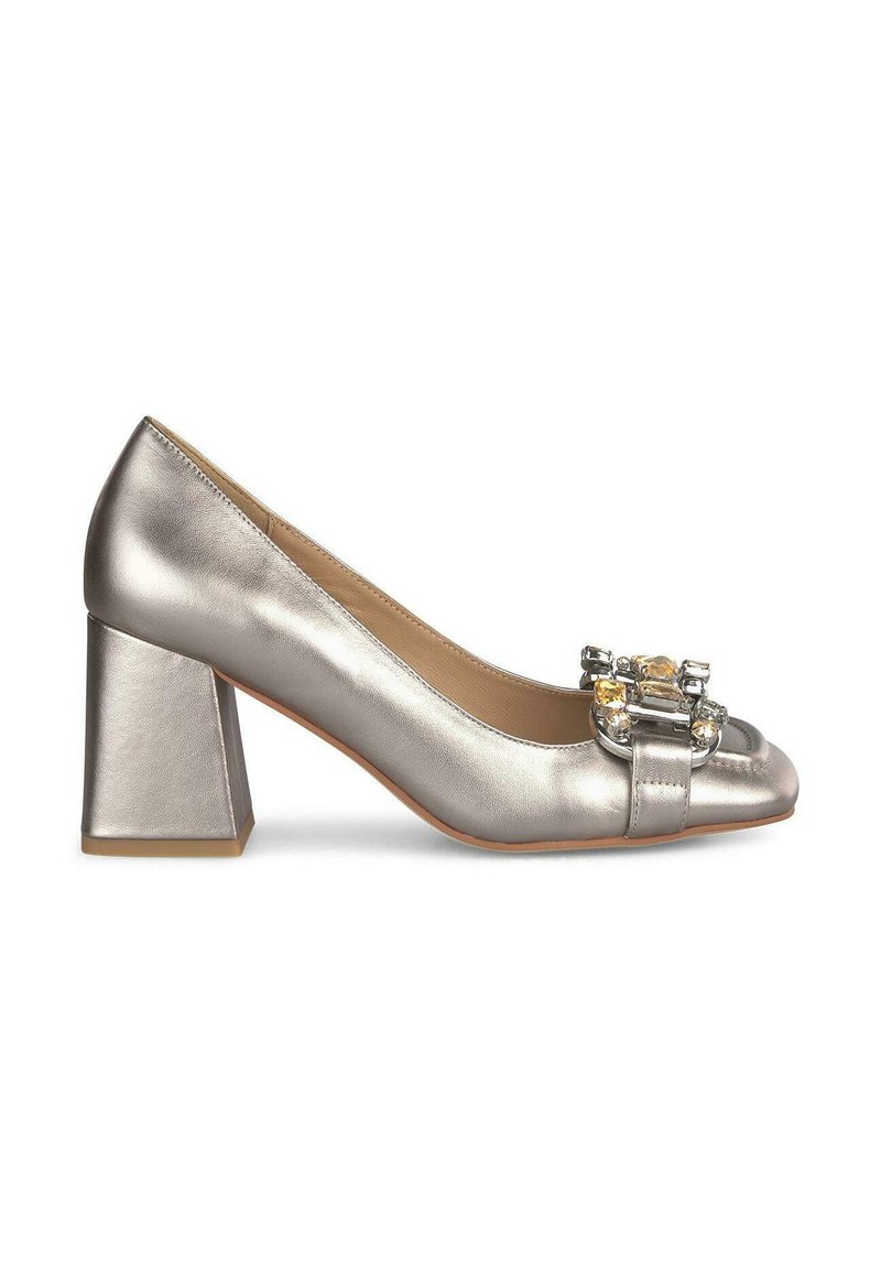 Scarpe con tacco a blocco in metallo argento, dalla punta arrotondata e con decorazioni frontali, che includono un fiocco piatto e accenti di gioielli.