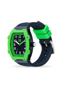 Reloj cuadrado con una esfera negra, marcadores de hora verdes llamativos y un bisel verde. Presenta una correa negra texturizada y herrajes de plata.