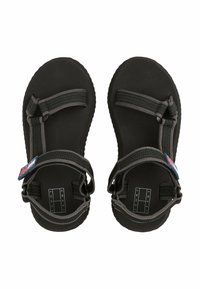 Sandalias negras con suela texturizada, que presentan correas ajustables de tela gris y una pequeña etiqueta de logo en rojo y azul.