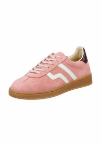 Zapatilla deportiva de ante rosa con franjas blancas y suela de goma marrón. Presenta una puntera redondeada, diseño con cordones y un interior suave color crema.