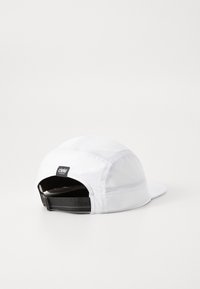 White cap with mesh panels, curved brim, and adjustable black strap at the back. Features a Ciele Athletics logo tag on the rear.