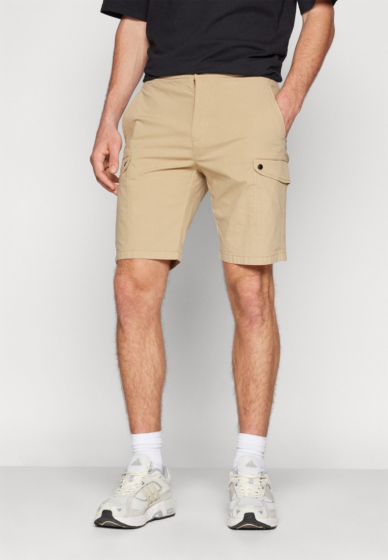 Pantaloni cargo beige con due tasche laterali, frontale piatto e taglio dritto. Realizzati in tessuto leggero, adatti per un abbigliamento casual.