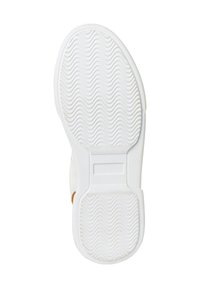 Suela de zapatilla blanca con una superficie texturizada que presenta un patrón ondulado, forma redondeada y un acento beige cerca del talón.