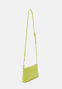 Borsa a tracolla verde lime con una forma rettangolare elegante, realizzata in materiale liscio, dotata di una cintura regolabile sottile e di una chiusura a cerniera.