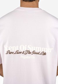 Weißes Baumwoll-T-Shirt mit Rundhalsausschnitt, auf dem Rücken mit dem bedruckten Text "Scent Of Summer" in großen weißen und braunen Buchstaben.