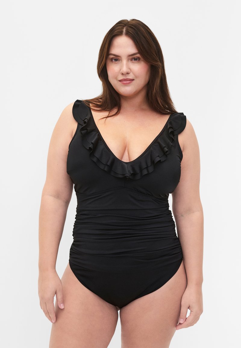 Maillot de bain une pièce noir avec un décolleté froncé, un devant en V, des côtés plissés et une texture lisse. Doté de larges bretelles.