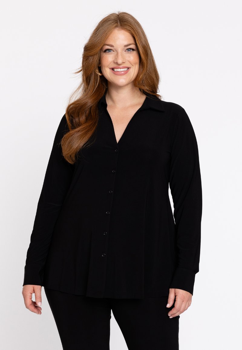 Schwarze Bluse mit langen Ärmeln, die einen kragenförmigen Ausschnitt, einen Knopfverschluss und eine lockere Passform mit einem gefalteten Saum hat. Glattes Gewebe mit leichtem Texture.