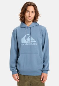 Modrá mikina s kapucí vyrobená z měkké látky, nabízí přední klokanku, stahovací kapuci a světle modré logo Quiksilver na hrudi.