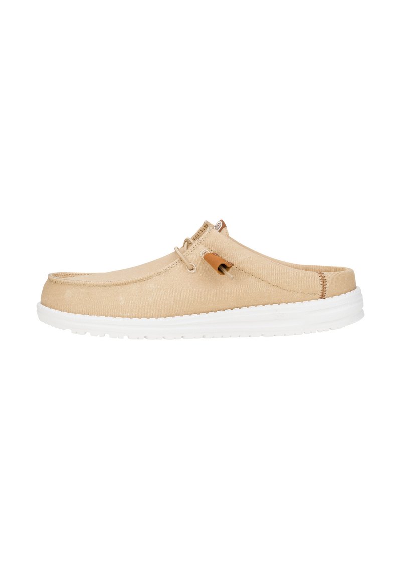 Scarpa slip-on beige con tomaia in tela testurizzata, suola in gomma bianca e cuciture minime. Presenta un piccolo accento marrone vicino al tallone.